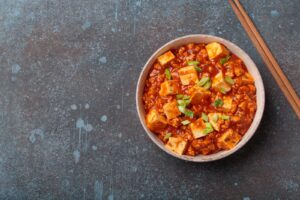 Bol de mapo tofu en sauce pimentée parsemé d'oignon vert