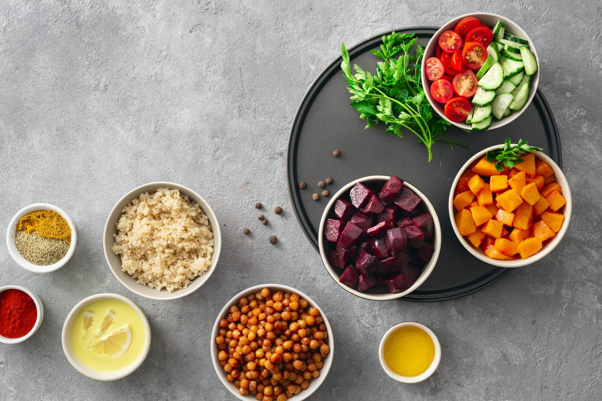 Bowls of spiced chickpeas, roasted pumpkin, beetroot, quinoa and raw vegetables