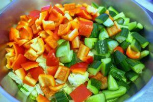 Crudités coupées en dés : poivrons, concombre et tomates dans un saladier