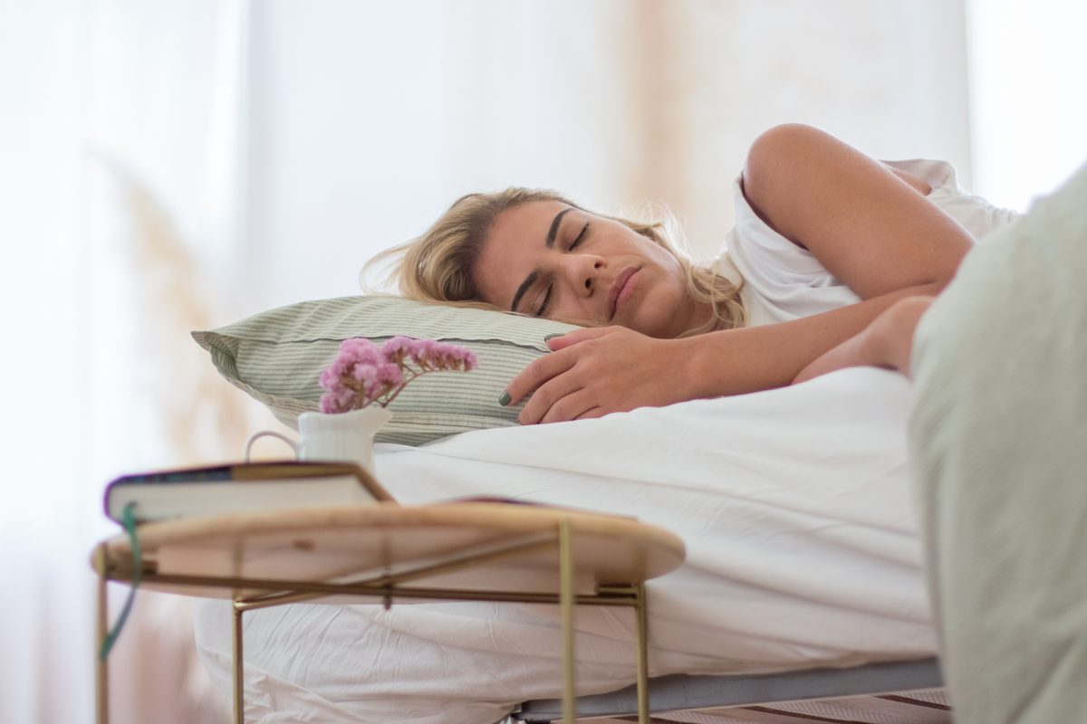 Woman sleeping peacefully in her bed in the morning light