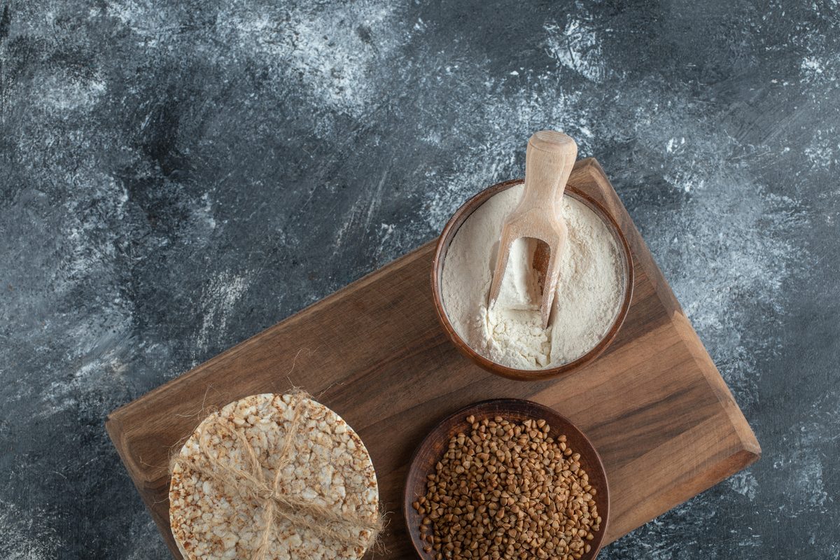 Galettes de riz, farine et sarrasin sur une planche en bois