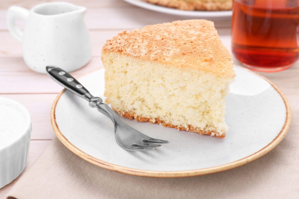 Slice of plain moist cake served on a plate with a fork