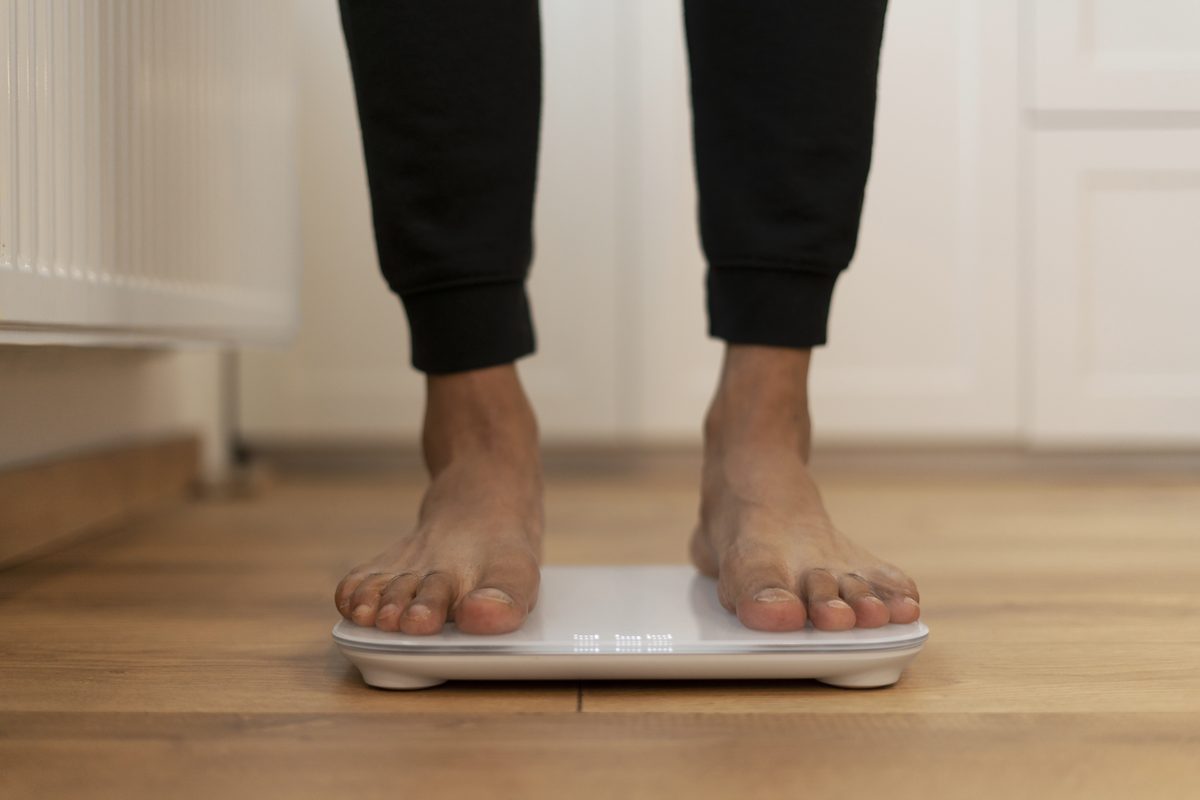 Bare feet on an electronic scale on a wooden floor