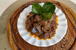 Rendang de bœuf mijoté servi avec des feuilles de combava