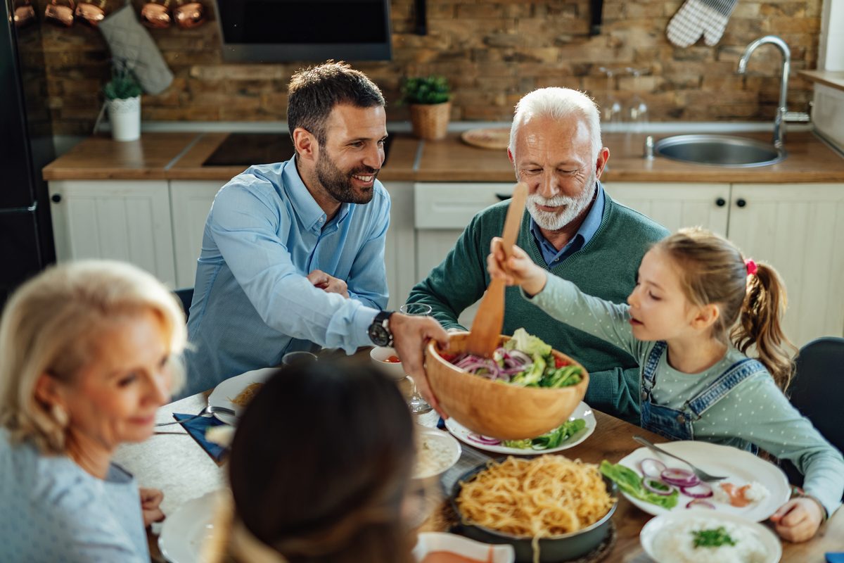 Family meal bringing together children, parents and grandparents around a salad