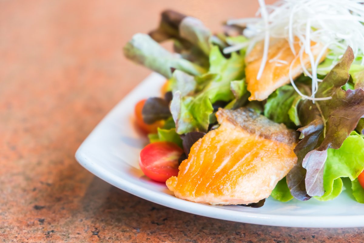 Green salad topped with pan-fried salmon fillet and cherry tomatoes
