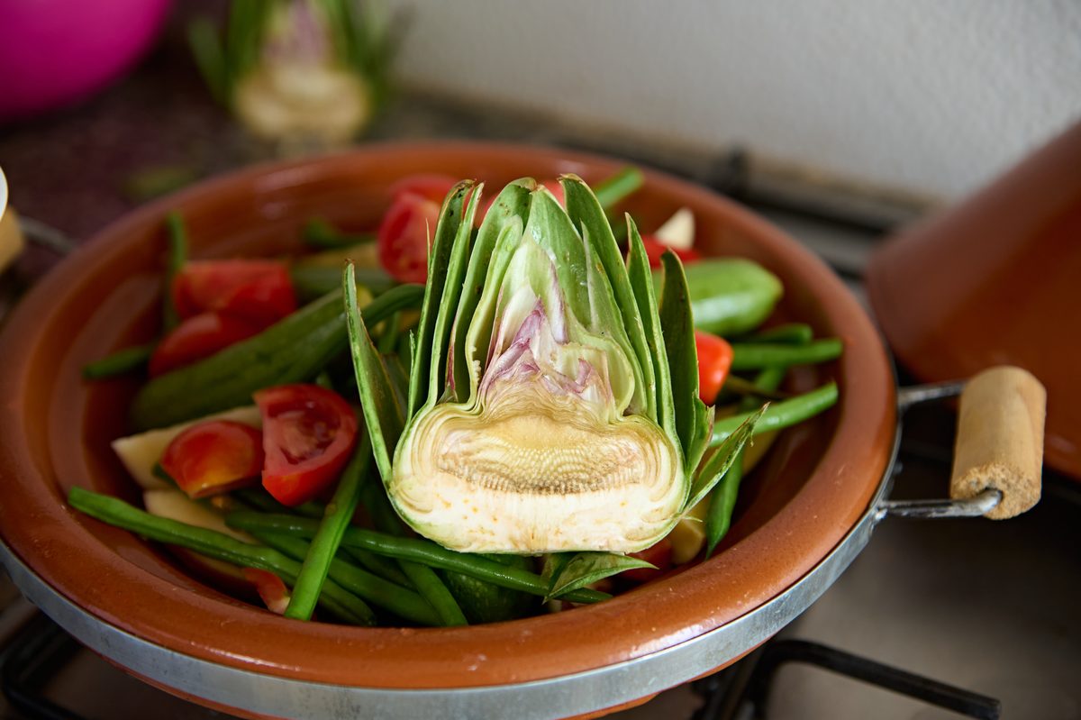 Tajine d'artichaut, haricots verts et tomates mijotant à feu doux