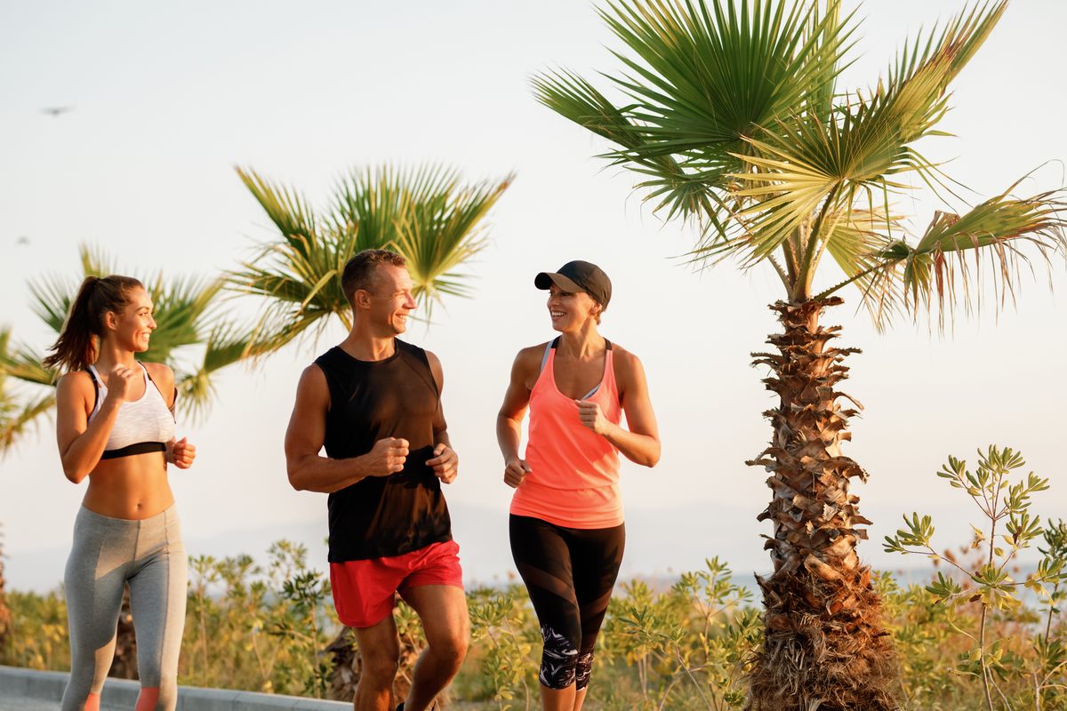 Trois amis faisant leur footing ensemble en discutant au bord de la mer