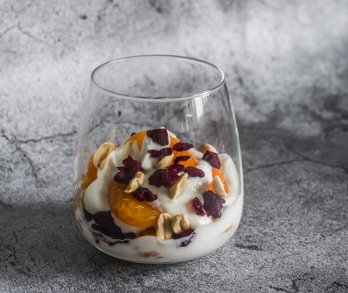 Greek yoghurt pot with cashew nuts, mandarin and dried cranberries